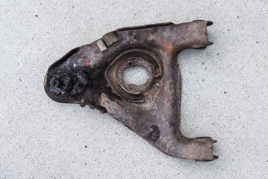 A factory OEM stamped steel control arm. A factory OEM stamped steel control arm.