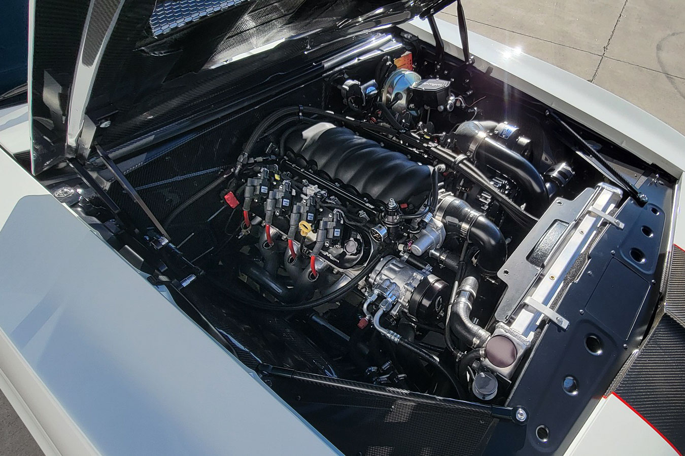 Engine bay featuring the Blueprint LS3 427 stroker engine with a D1X Procharger and custom plumbing.